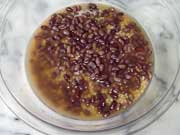 大きめの耐熱容器に小豆の茹で汁と米を入れ小豆を上に乗せる