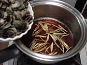 煮立てた煮汁に生姜とミル貝を入れる