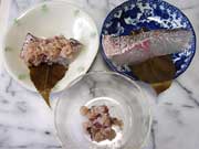 お皿に桜の葉を置き鯛の切り身・赤飯を上から乗せ巻く